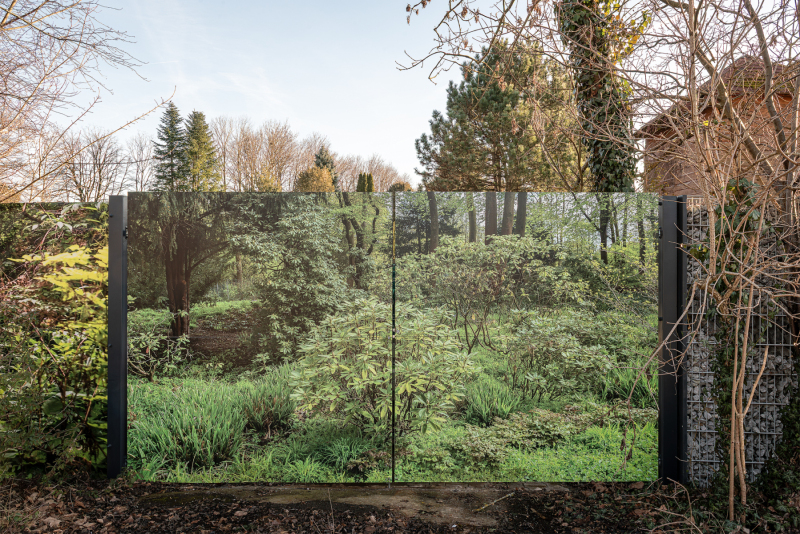 A gate with a photo of bushes and trees on it.